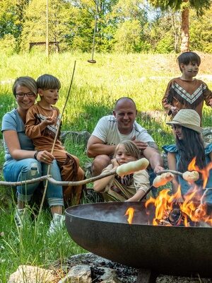 Familienhotel Mein Krug im Fichtelgebirge: Familie genießt einen gemeinsamen Moment beim Lagerfeuer mit Stockbrot Teil der besonderen zu buchbaren Herzmomente